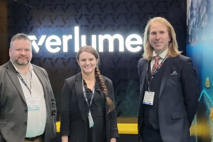 Tre personer framför Verlumes upplysta mässmonter på Subsea Expo