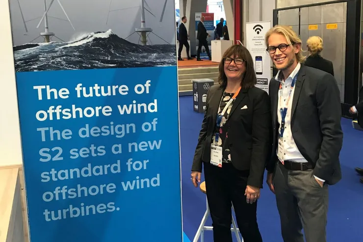 Två personer vid SeaTwirls blå mässvägg med texten »The future of offshore wind«, i en mässhall