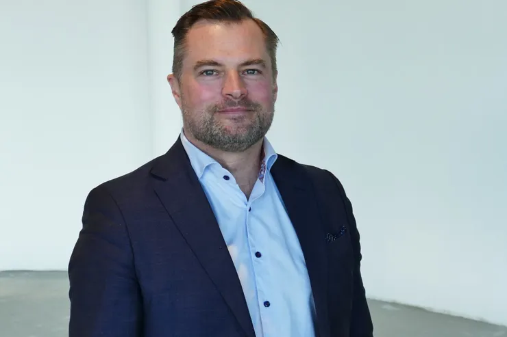 Johan Sandberg i mörkblå kavaj och ljus skjorta, fotograferad inomhus