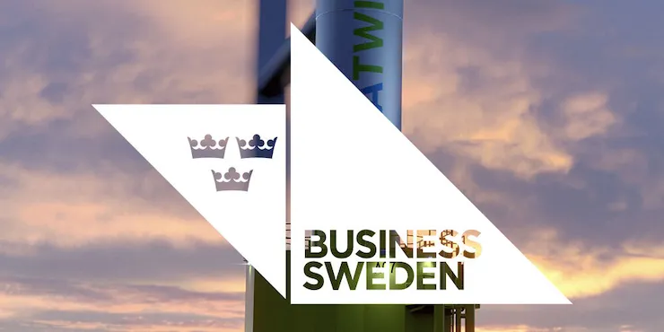 Vindkraftverket i solnedgång med Business Swedens logotyp i en vit triangel över bilden